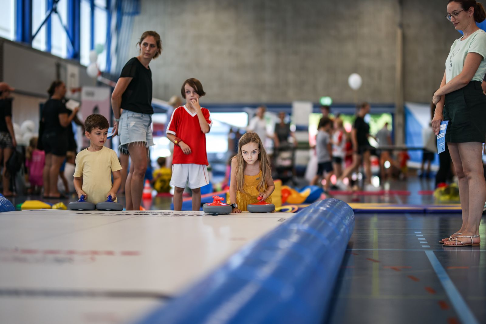 Ein Mädchen beim Curling in der Turnhalle - ein aufblasbarer Rink